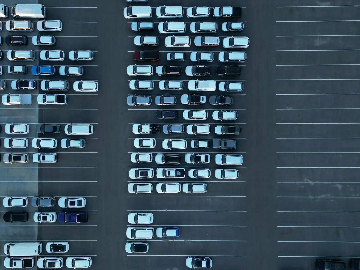 Aerial view of a car park with rows of cars and empty bays