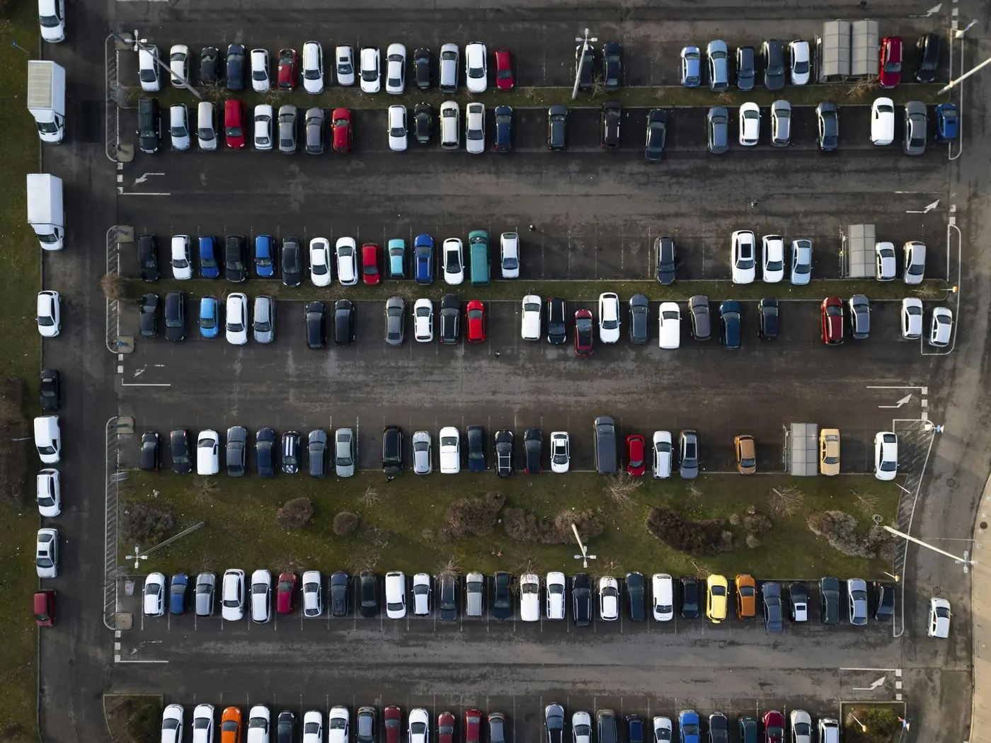 Aerial view of a large car park with rows of parked cars
