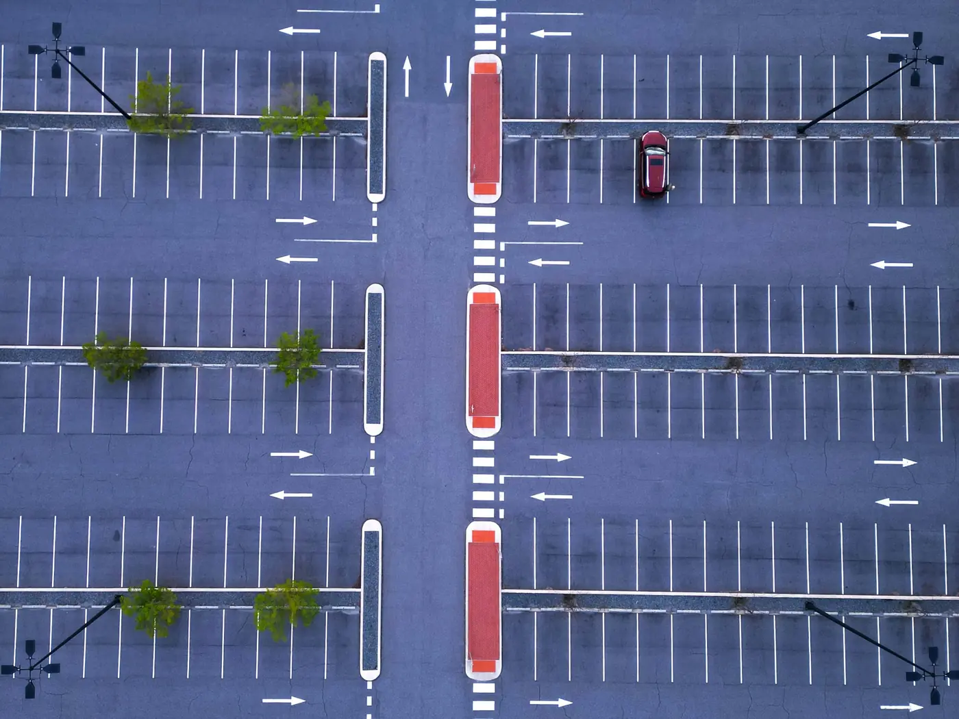 Overhead view of an almost empty car park with marked bays