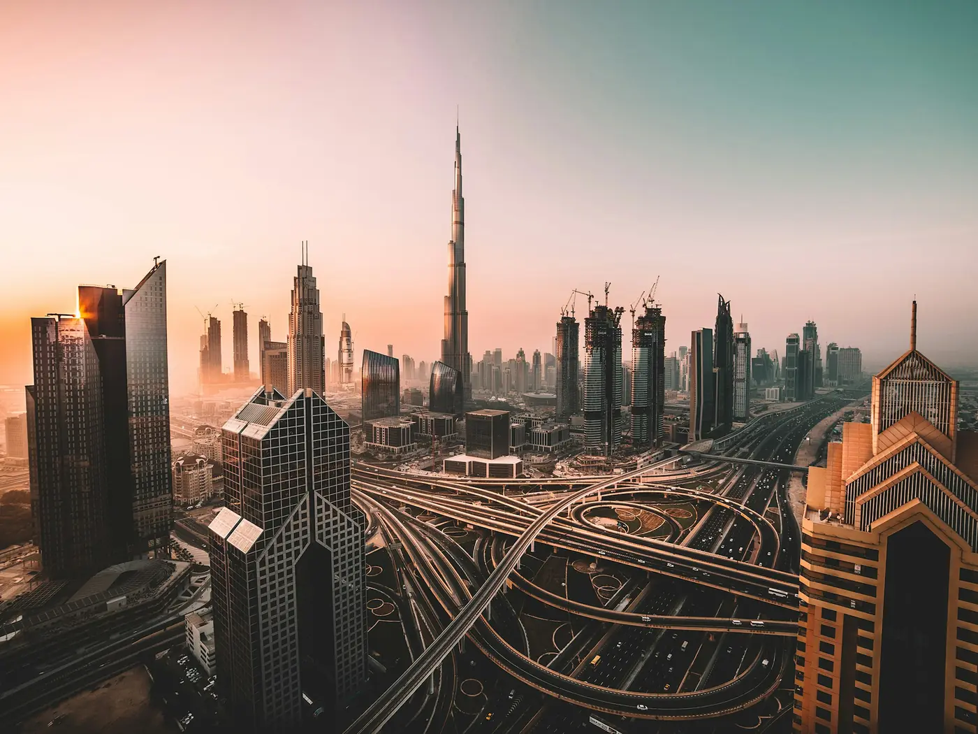 Dubai skyline with the Burj Khalifa above a highway interchange at sunset