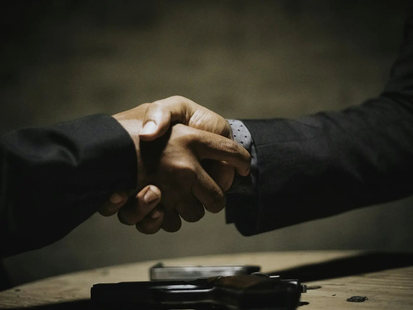 Two business partners shaking hands over a table